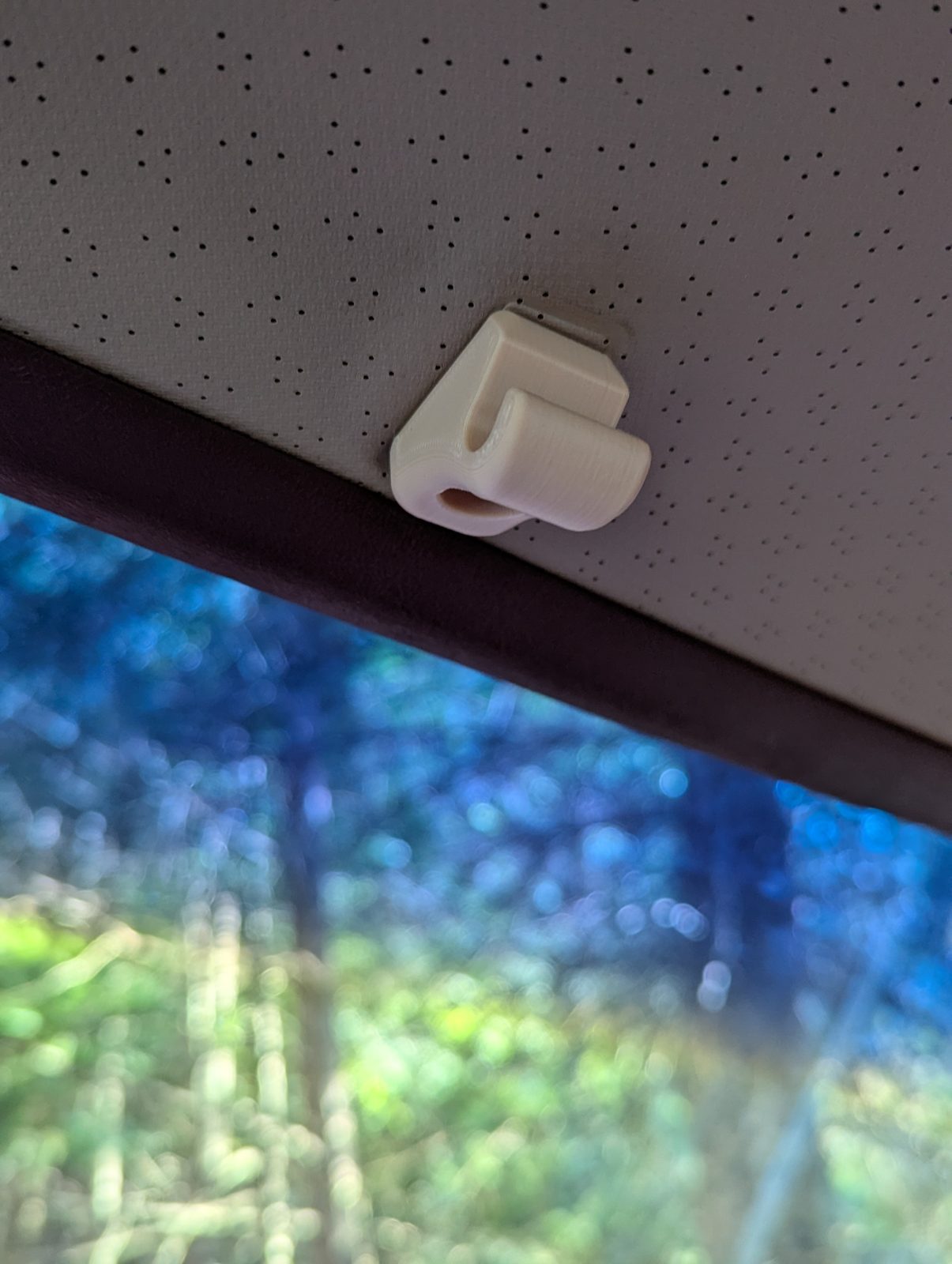 The tan v12 clip on the headliner above the windshield, seen from further back.