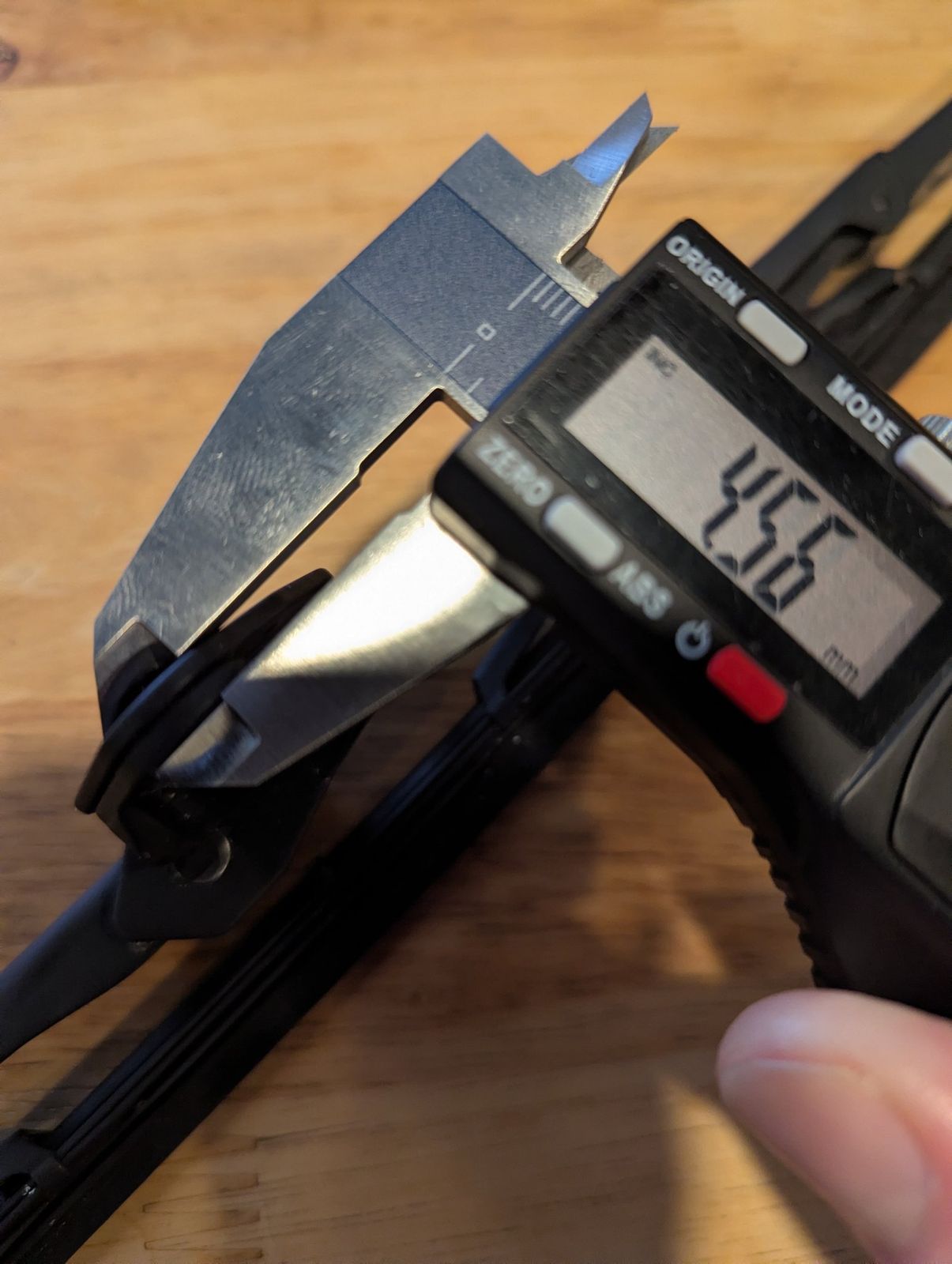 Digital calipers measuring the blade holder on the stock wiper.