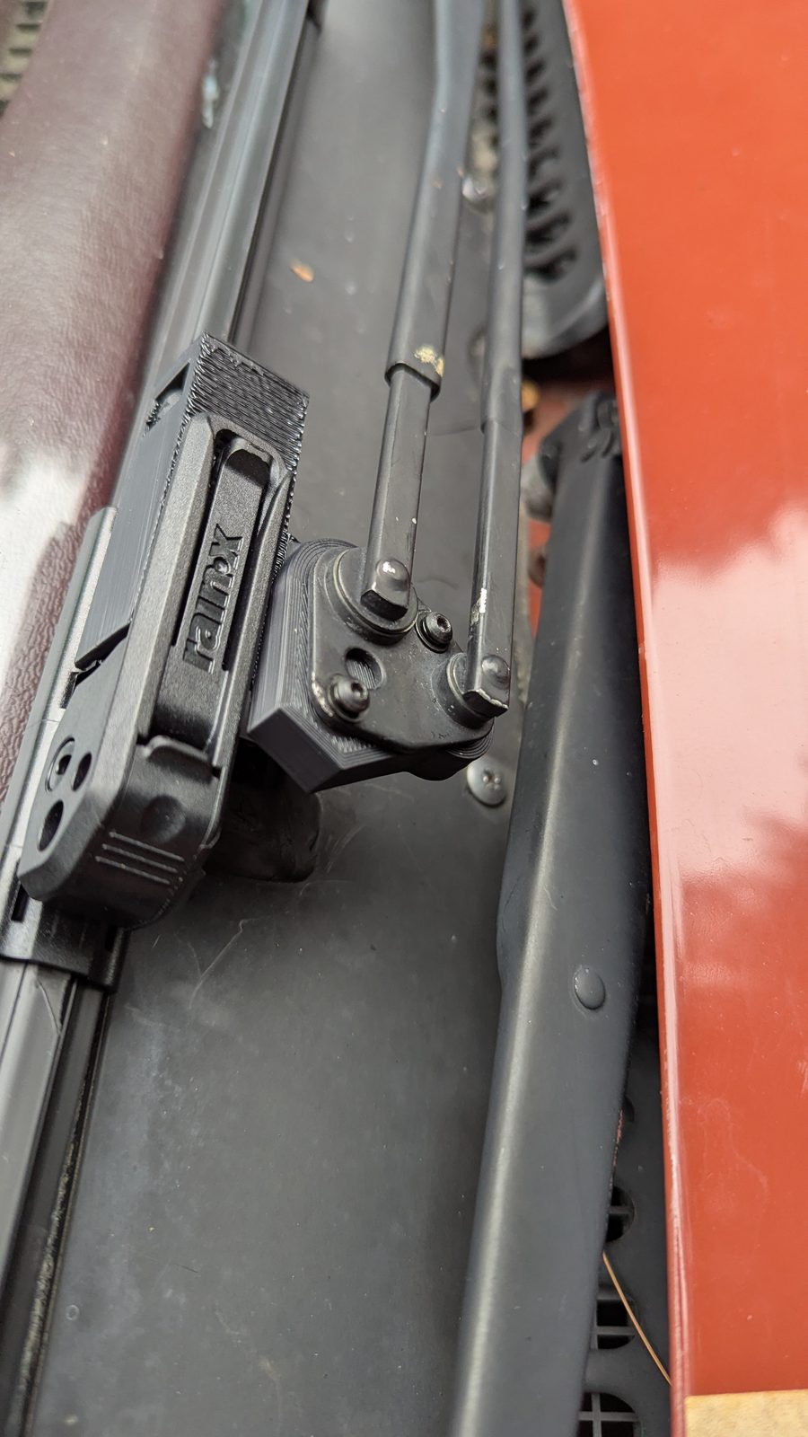 A printed adaptor mounted on the end of the original wiper arm, with the blade attached.